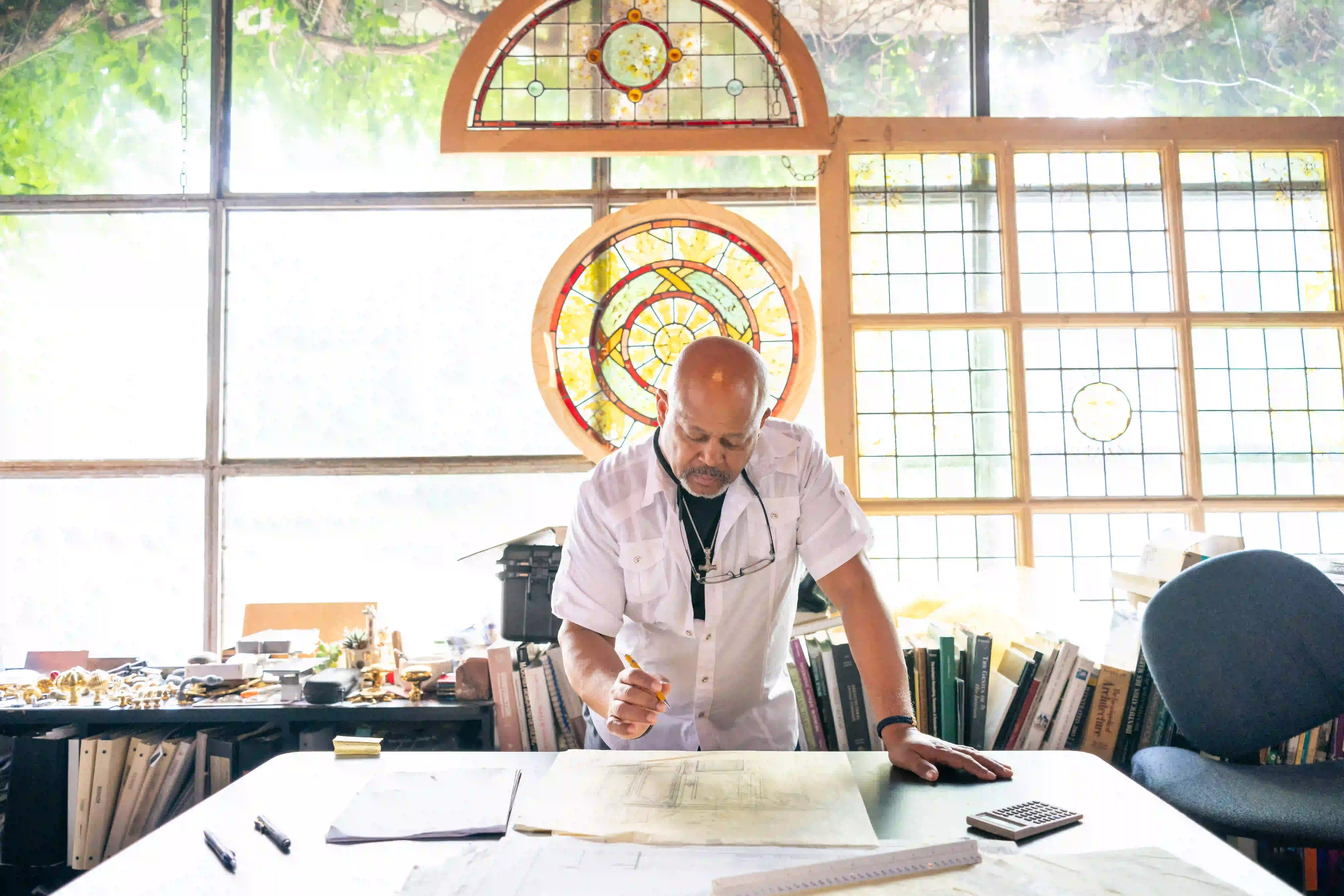 Selektiver Fokus eines Autohändlers mit Brille, der Kunden im Büro ansieht.